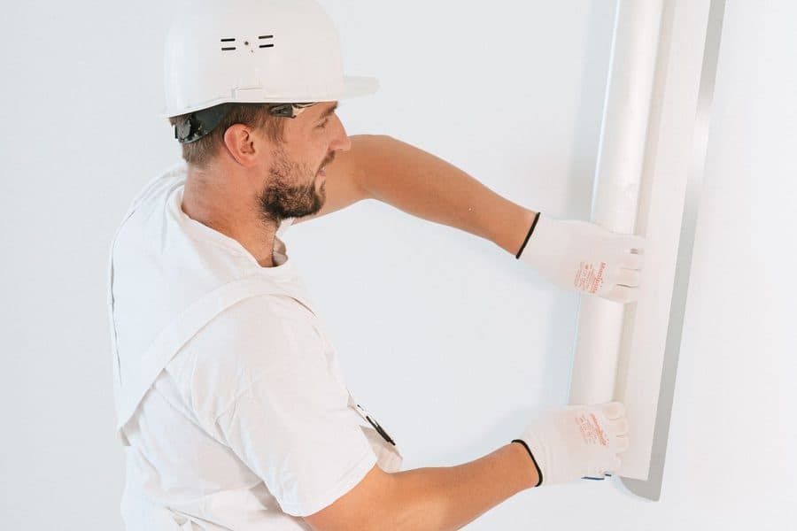 Pose d'une plaque de placo par un professionnel